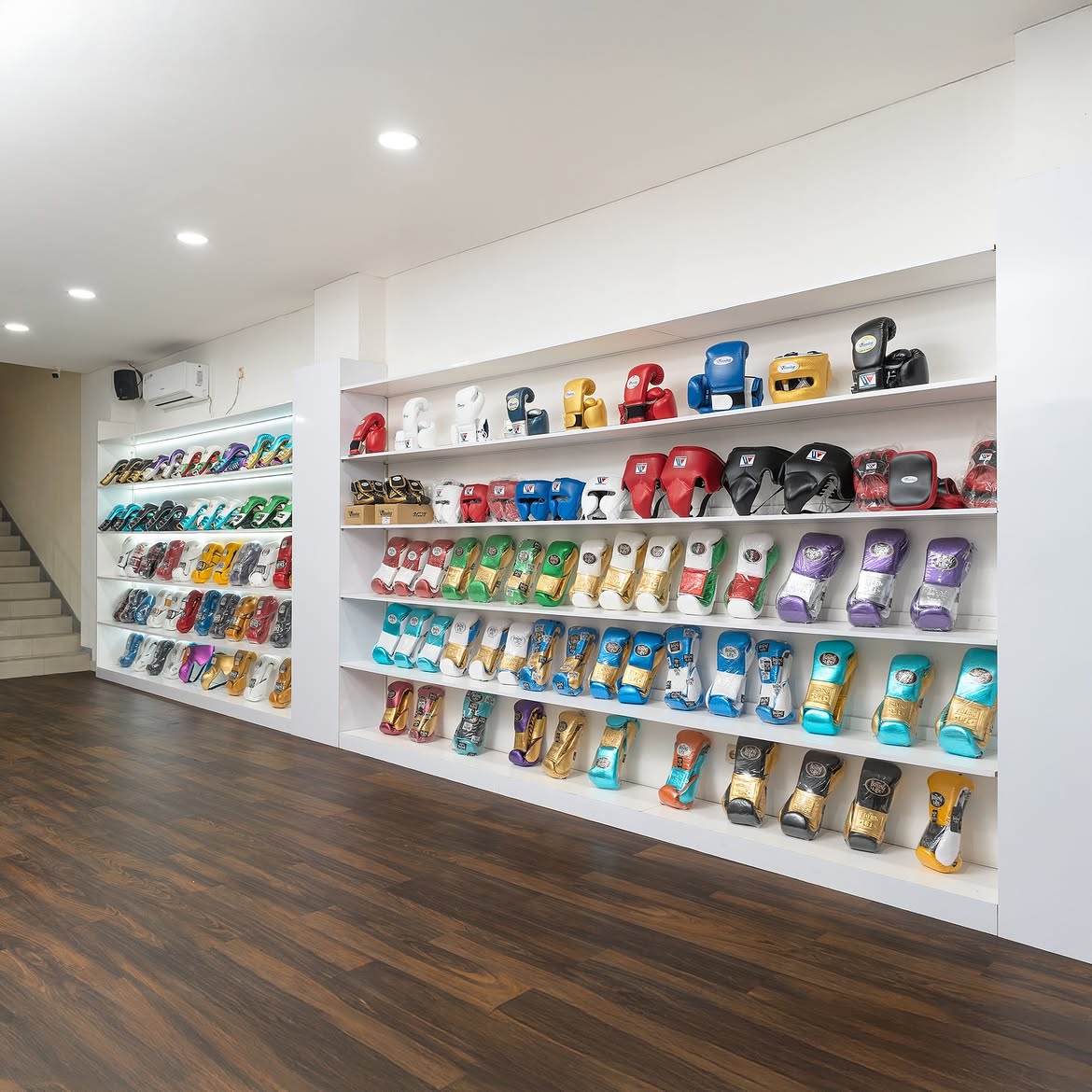 Jakarta Boxing showroom — shelves of boxing gloves, headgear, shin guards and protective equipment.