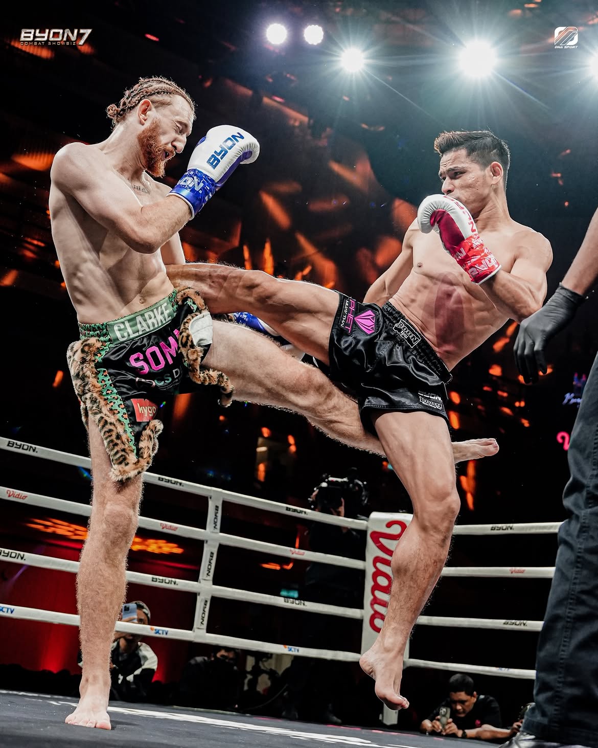 Aaron Clarke 'The Bounty Hunter' landing a kick in the ring wearing black and leopard-print Primal Muay Thai shorts with Clarke and Soma branding.
