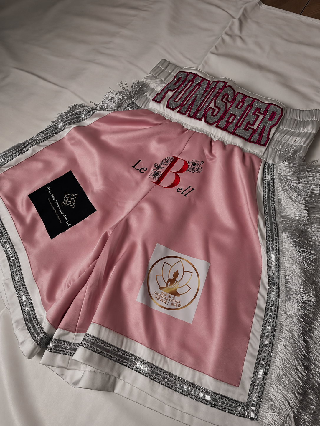 Pink, white and silver Punisher boxing trunks with fringe.