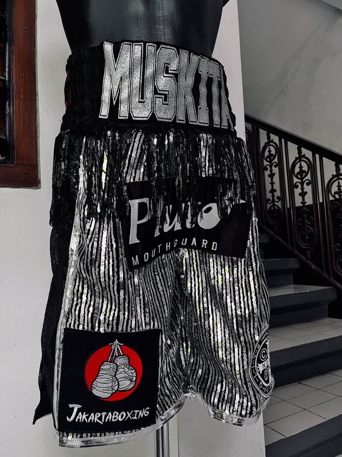 Black and silver Muskita boxing trunks with sequin panels and custom patches.