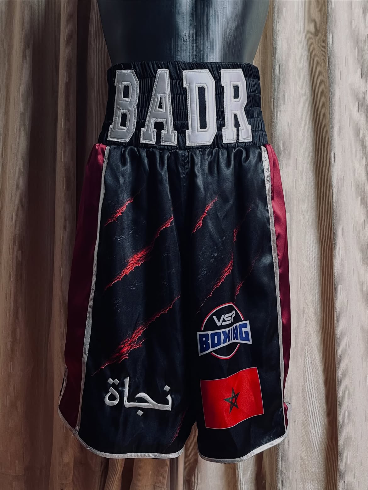 Black, red and silver Badr boxing trunks with dragon claw graphics.